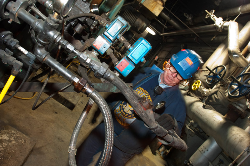 man working on pipes in factory