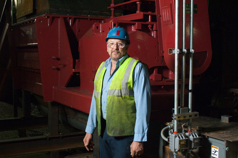 man standing in front of boiler in factory