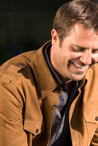 close up of man smiling in suede jacket